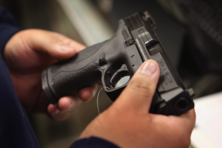 Man holding and examining a Smith & Wesson M&P semi-automatic pistol